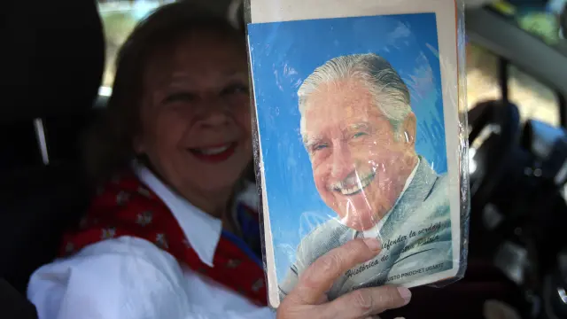Una mujer muestra una foto de Pinochet.
