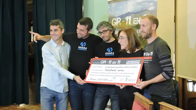 Los cuatro deportistas entregando el cheque a Aurora Calvo, presidenta de la Asociación Española contra el Cáncer en Huesca.