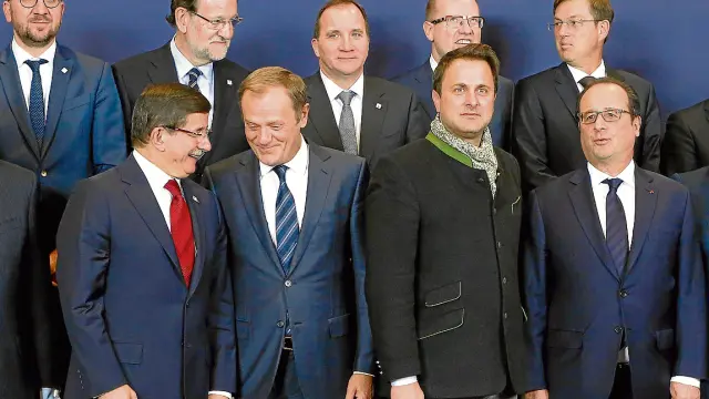 Abajo, el primer ministro turco, Ahmet Davutoglu, habla con Donald Tusk (Consejo Europeo), junto al luxemburgués Xavier Bettel y el francés François Hollande. Arriba, Mariano Rajoy.