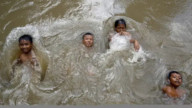 Varios niños indonesios se bañan en un río altamente contaminado.