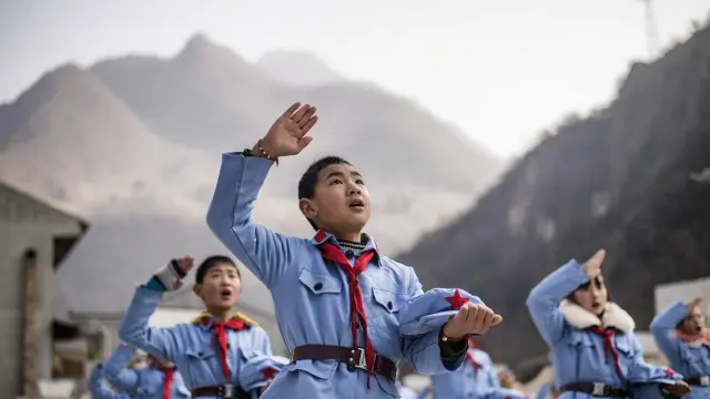 Un niño uniformado canta tras izar la bandera nacional en la escuela de primaria del Ejército Rojo de Beichuan, en la provincia de Sichuan, al suroeste de China. Fotografía tomada el 21 de enero de 2015