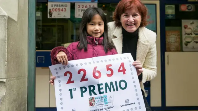 Isabel Lalmolda, lotera de la Administración número 1, y su hija Irene muestran el cartel con el número premiado