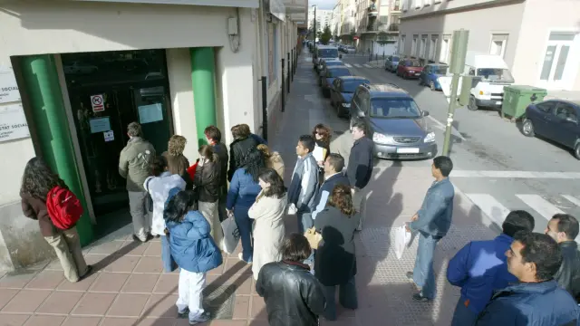 Unos ciudadanos guardan fila ante una oficina de la Seguridad Social.