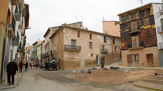 Los restos de la Hoguera permanecen en la plaza. A la derecha, la casa más dañada por las llamas.