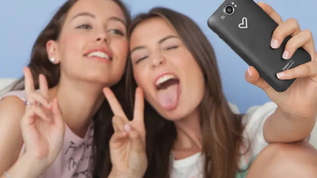 Dos jóvenes disfrutan haciendo un selfie.