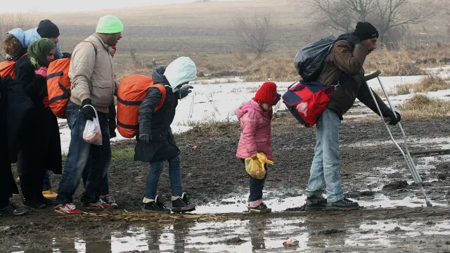 Refugiados se dirigen a un campamento temporal en Presevo (Serbia).