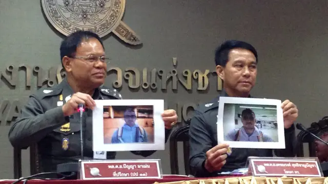 Dos policías tailandeses muestran fotografías de Artur Segarra, el posible autor del crimen de David Bernat.