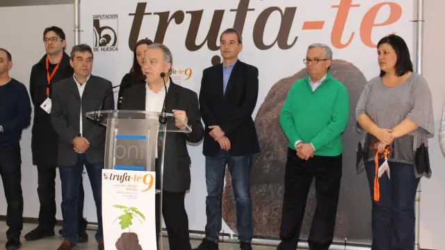 El presidente de la DPH, Miguel Gracia, rodeado por el alcalde de Binéfar, a su espalda, Alfonso Adán, y por los cocineros del certamen.
