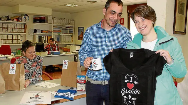 Marta Fiestas, junto al alcalde de Grañén, Carlos Sampériz, enseña la camiseta recibida al censarse.