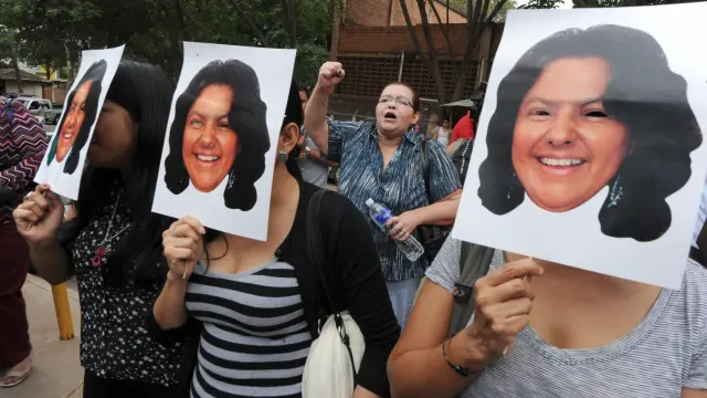 Varias mujeres protestan con caretas de Berta Cáceres.