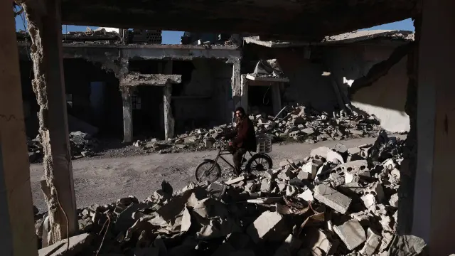 Un hombre pasa junto a un edificio derribado cerca de Damasco.