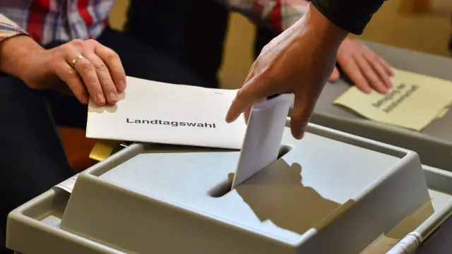 Un votante alemán deposita su papeleta en una urna.