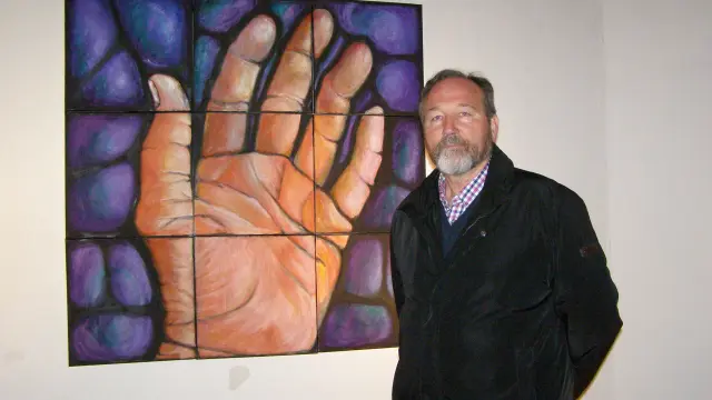 Pie de foto: El pintor Carlos Gorrindo, junto a uno de sus cuadros expuestos.