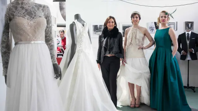 Elena Peiró, Cristina Alanís y Lorena Tormes, junto a algunos de los vestidos de novia que se mostraron.