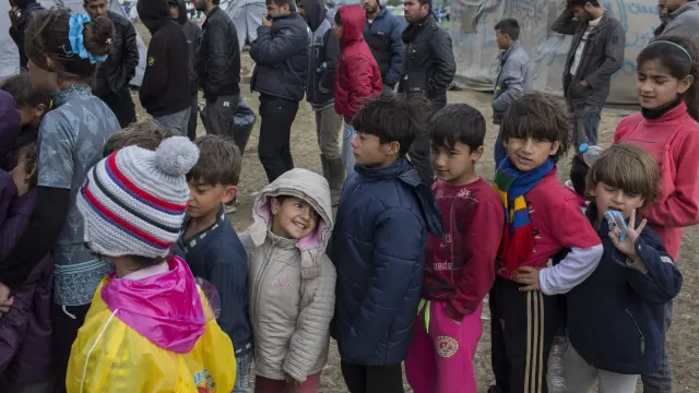 Niños refugiados hacen fila en el campo de Idomeni (Grecia) para obtener comida.