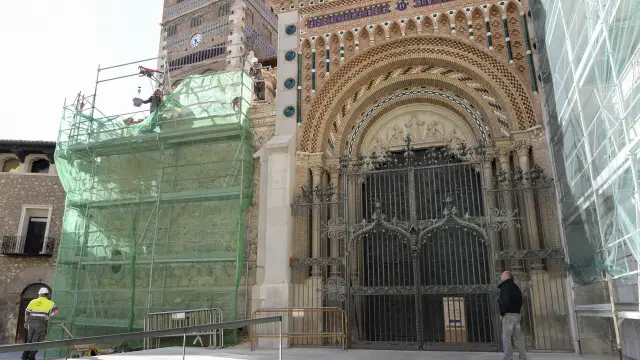La verja del pórtico de la catedral, en medio de los andamios de las fachadas.