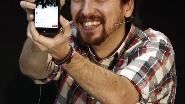 Pablo Iglesias (Podemos) muestra su móvil en un acto público.