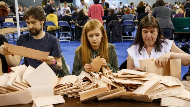 Los miembros de las mesas electorales recontando votos esta madrugada en Glasgow (Escocia).