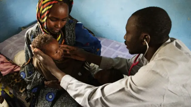Un doctor examina a un bebé con malnutrición en El Fasher, capital del Estado de Darfur del Norte.