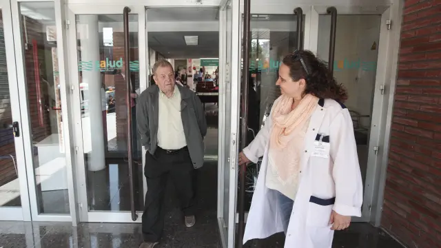 Una voluntaria abre la puerta del área de consultas externas del Obispo Polanco a un paciente.