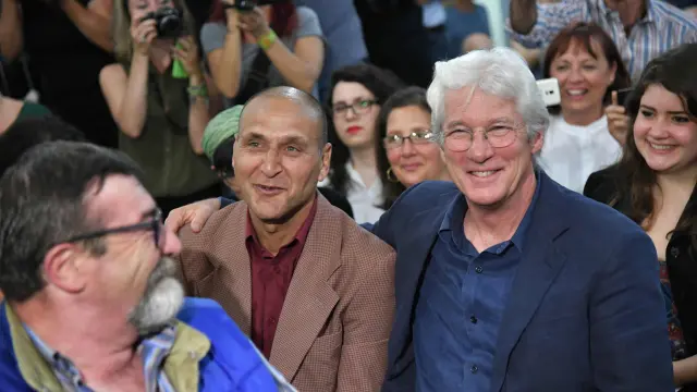 Richard Gere posa junto a un refugiado en la presentación de la película 'Ivisibles'.