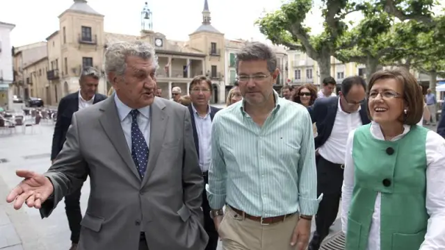 El ministro de Justicia en funciones, Rafael Catalá (c), acompañado por el expresidente del Congreso Jesús Posada (i), y la presidenta del PP de Soria, Marimar Angulo (d), en El Burgo de Osma.