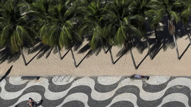 Un hombre duerme en una playa de Río de Janeiro.