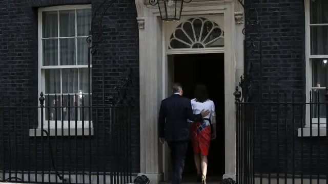 Cameron y su esposa entrando en su residencia.