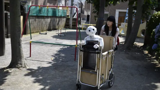 Ota y su robot blanco de 1,2 metros de altura mientras pasean por el barrio tokiota de Nippori.