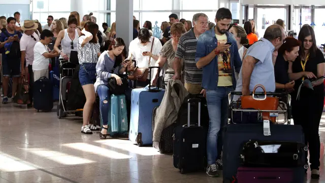 Filas ante los mostradores de Vueling en el aeropuerto de El Prat durante este martes.