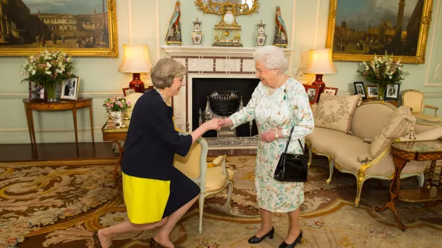 Theresa May saludando a la reina Isabel II.