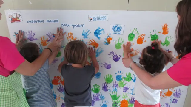 Alumnos de Infantil de la escuela de Barbastro plasman sus manos sobre el mural.