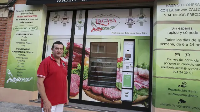 Antonio Lacasa, propietario del establecimiento, posa delante de la máquina expendedora
