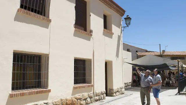 Dos vecinos de Villarroya de los Pinares observan el balcón desde el que cayó el joven.