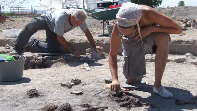 Los arqueólogos Jaime Vicente y Beatriz Ezquerra extraen objetos domésticos de una de las viviendas de la ciudad romana de la Caridad de Caminreal.