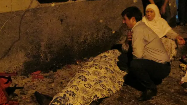Una pareja llora ante el cuerpo de una de las personas fallecidas en el ataque.