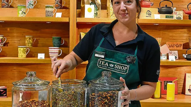 Isamar Gutiérrez, una de las dependientas de Tea Shop en el Coso de Zaragoza, con tres variedades de té.