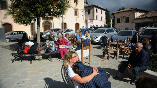 Vecinos de Accumoli sentados en una plaza tras el terremoto que ha asolado el centro de Italia.