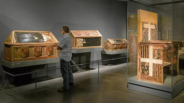 Un visitante contempla las tres cajas sepulcrales de Sijena expuestas en Lérida.