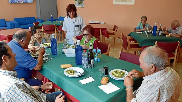 Varios vecinos degustan el menú del comedor para personas mayores de Litago.