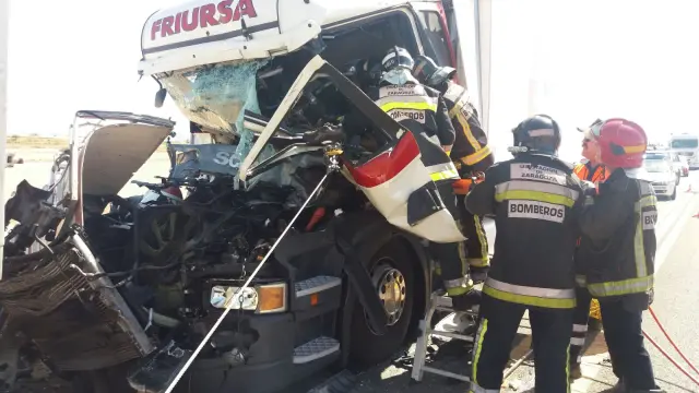 Los bomberos durante la excarcelación del conductor de uno de los camiones.