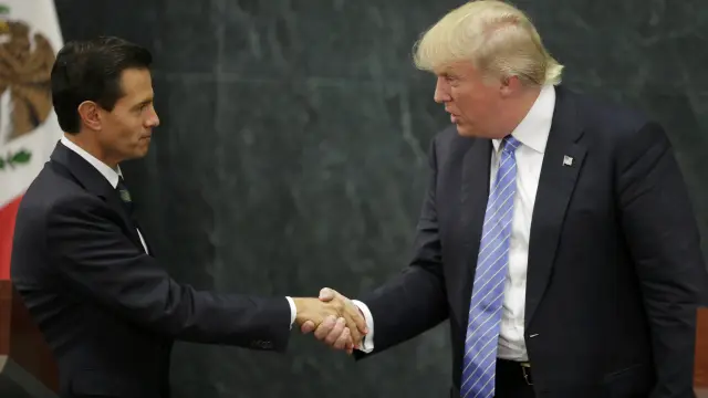 El presidente mexicano, Enrique Peña Nieto, y el candidato republicano a la Casa Blanca, Donald Trump, estrechándose la mano en una rueda de prensa hoy en Ciudad de México.