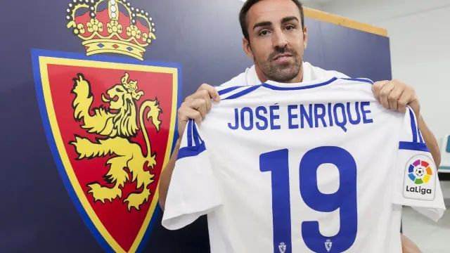 José Enrique, con su nueva camiseta con el dorsal '19', posa tras su presentación junto al escudo del Real Zaragoza.