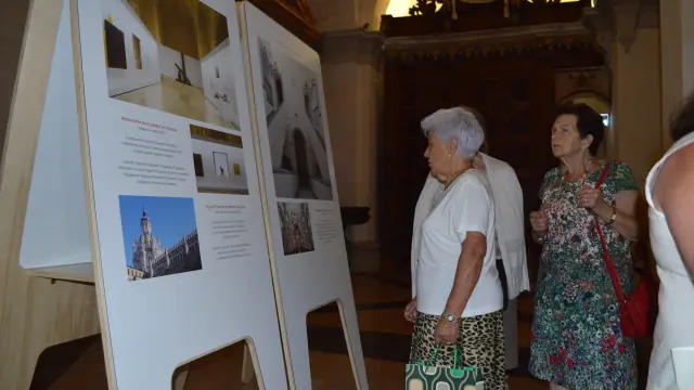 Varios visitantes observan los paneles informativos instalados en la catedral de Tarazona.