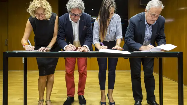 Firma del acuerdo por parte de los representates de IU (Patricia Luquin), CHA (Gregorio Briz), Podemos (Maru Díaz) y PSOE (Javier Sada), este martes en las Cortes de Aragón.