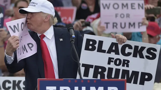 Trump besa un cartel donde nombra a las mujeres.