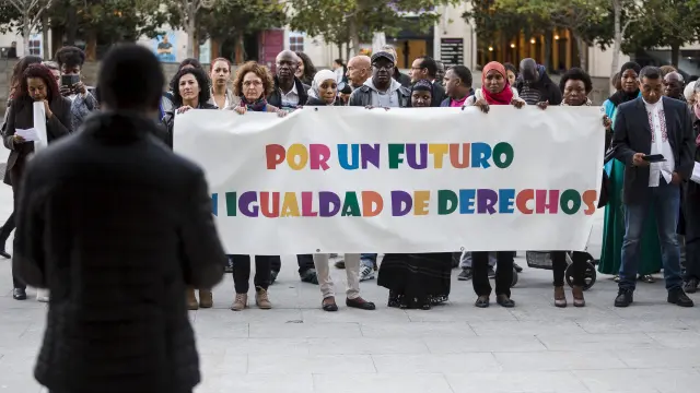 Alrededor de un centenar de personas se han concentrado este jueves por la tarde frente a la Delegación del Gobierno de Aragón para solicitar un sistema justo de acceso a la nacionalidad española por residencia
