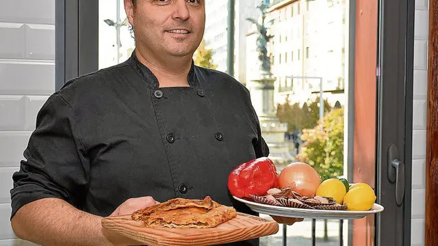 José Miguel Giménez, de La Pulpería, con una empanada de zamburiñas y con los ingredientes que ha utilizado.