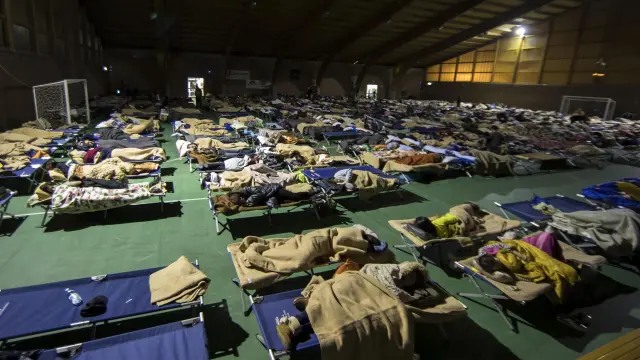 Varios residentes duermen en un pabellón deportivo reconvertido en albergue temporal en la ciudad de Camerino.
