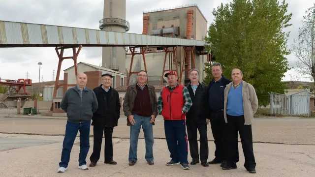 Extrabajadores de la térmica y miembros de la Asociación Patrimonio Minero posan ante la central.